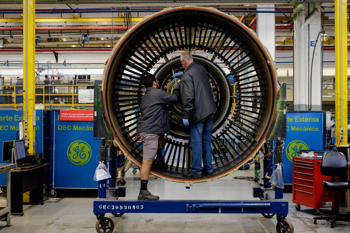 (FILES) In this file photo taken on June 11, 2016 men work with a jet engine at General Electric (GE) Celma, GE's aviation engine overhaul facility in Petropolis, Rio de Janeiro, Brazil. A Chinese intelligence officer was sentenced to 20 years in prison by a US court November 16, 2022 for stealing technology from US and French aerospace firms, the Justice Department said. (Photo by YASUYOSHI CHIBA / AFP)