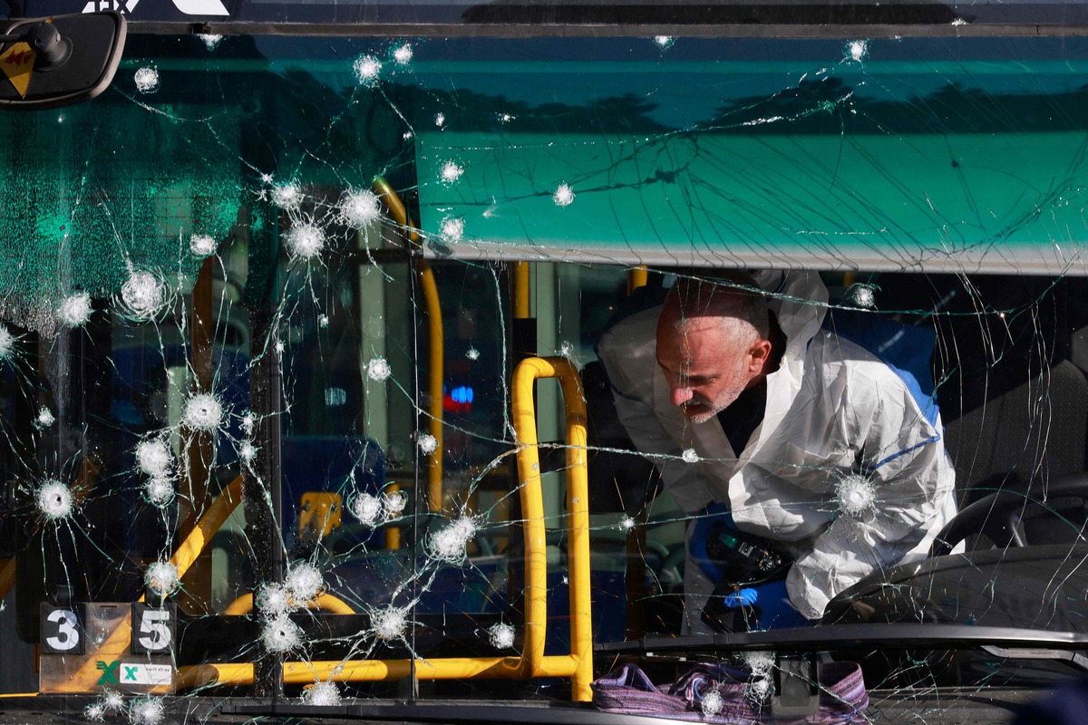 An Israeli forensic expert works at scene of an explosion in Jerusalem at a bus stop which wounded at least seven people, two of them seriously, on November 23, 2022. (Photo by Menahem KAHANA / AFP)