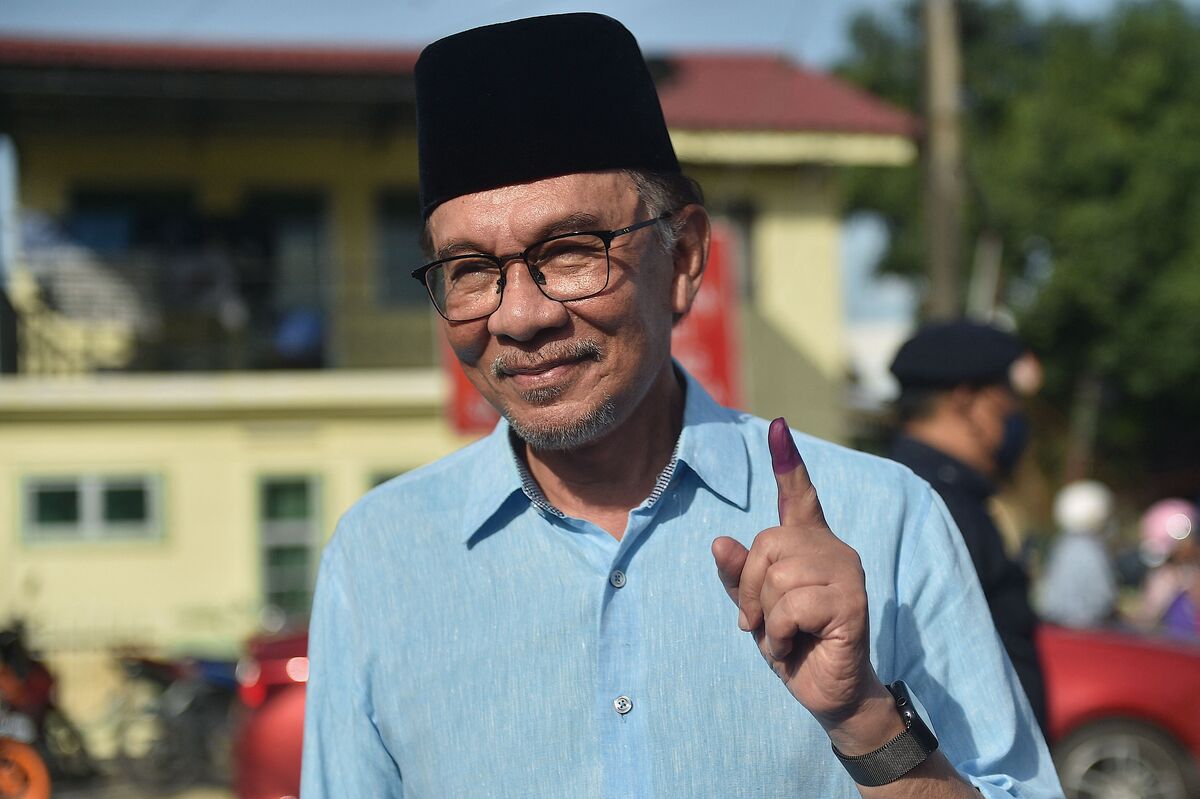 (FILES) In this file photo taken on November 19, 2022 Malaysias opposition leader Anwar Ibrahim, chairman of the Pakatan Harapan (Alliance of Hope), shows his inked finger after voting at a polling station during the general election in Permatang Pauh, Malaysia's Penang state. Malaysian opposition leader Anwar Ibrahim has been appointed prime minister, the palace said in a statement on November 24, 2022, ending a days-long political impasse after inconclusive polls. (Photo by Arif Kartono / AFP)