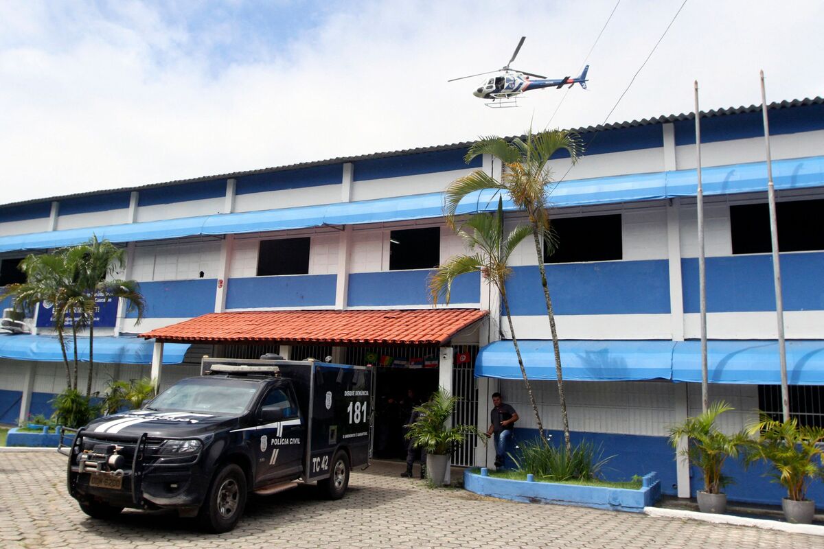 Police officers stand at the entrance of the Primo Bitti State School, one of two schools where a shooting took place, after an armed man opened fire, in Aracruz, Espirito Santo State, Brazil, on November 25, 2022. At least three people including an adolescent girl were killed and 11 others wounded when a man opened fire on two schools in southeastern Brazil. Authorities arrested the suspected shooter after a manhunt, state Governor Renato Casagrande said. (Photo by KADIJA FERNANDES / AFP)