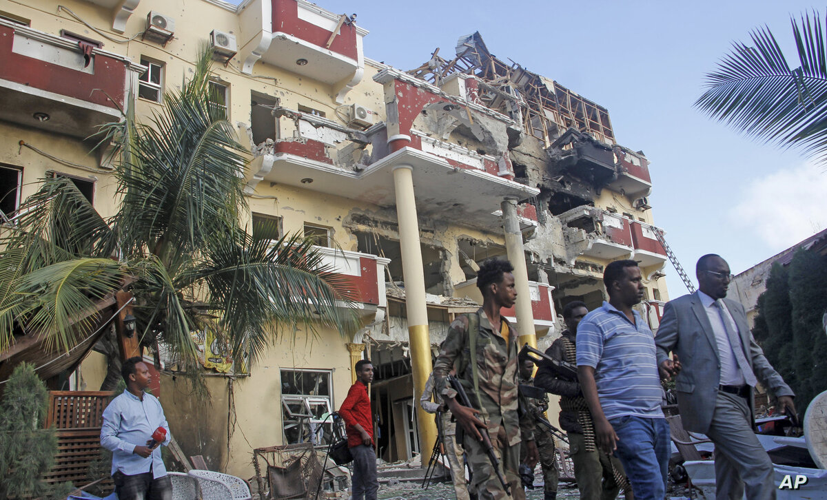 Security forces and others walk in front of the damaged Hayat Hotel in the capital Mogadishu, Somalia Sunday, Aug. 21, 2022. Somali authorities on Sunday ended a deadly attack in which at least 20 people were killed and many others wounded when gunmen from the Islamic extremist group al-Shabab, which has ties with al-Qaida, stormed the Hayat Hotel in the capital on Friday evening. (AP Photo/Farah Abdi Warsameh)