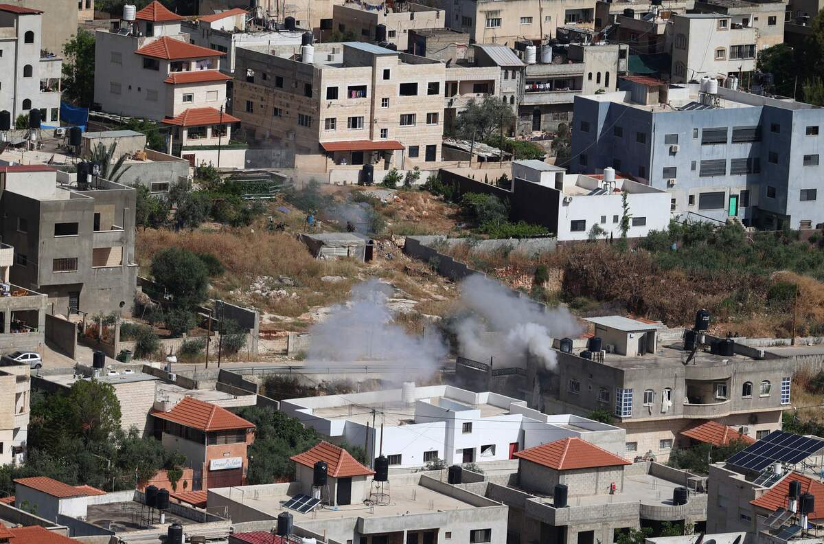 Smoke billows from a house in the Jenin refugee camp on May 13, 2022 during an Israeli military raid. Israel was bolstering security forces in Jerusalem ahead of veteran Al Jazeera journalist Shireen Abu Akleh's funeral, two days after she was killed during an Israeli army raid. Fresh violence erupted today in the northern West Bank, with an Israeli raid on the Jenin refugee camp resulting so far in a wounded Palestinian, according to official Palestinian news website Wafa. (Photo by JAAFAR ASHTIYEH / AFP)