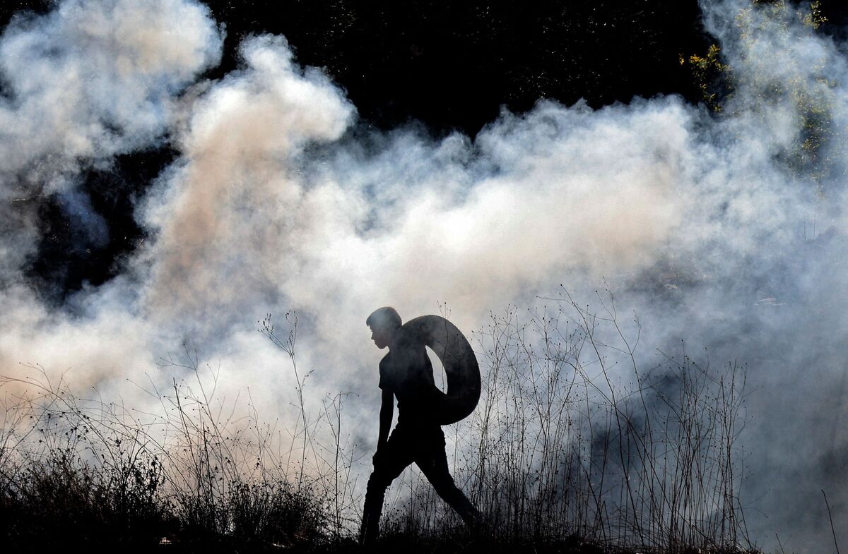 TOPSHOT - Palestinian demonstrators burn tyres during a rally to protest the resumption of construction at the settlement outpost of Eviatar near the Palestinian village of Beita, south of Nablus in the occupied West Bank on November 18, 2022. (Photo by Jaafar ASHTIYEH / AFP)