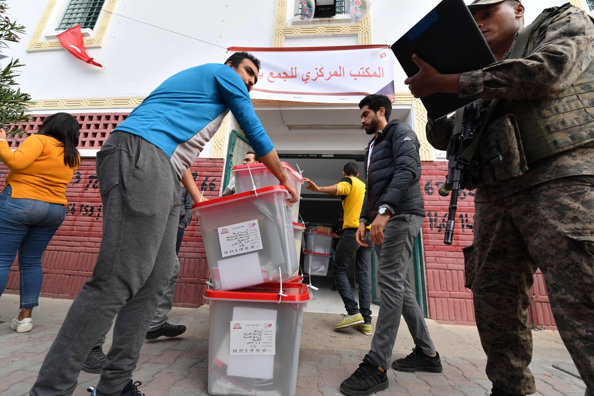 Employees load ballot boxes into a supervised military truck that will transport them to a polling station in the district of Ariana near Tunis on December 16, 2022, ahead of tomorrow's legislatives elections. (Photo by FETHI BELAID / AFP)