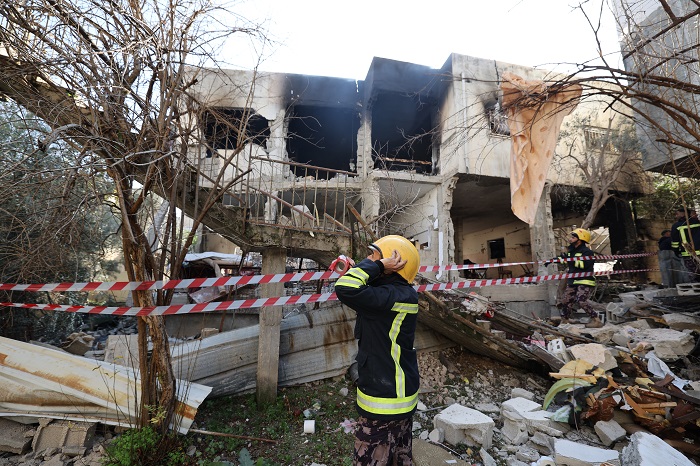 EDITORS NOTE: Graphic content / A rescuer is pictured in front of a building damaged and burned by Israeli troops during a raid on the West Bank's Jenin refugee camp, on January 26, 2023. - An Israeli raid on Jenin refugee camp today killed 9 Palestinians including an elderly woman, Palestinian officials said, also accusing the army of using tear gas inside a hospital.Israel's army declined to comment when asked by AFP about the health minister's tear gas allegation. (Photo by JAAFAR ASHTIYEH / AFP)