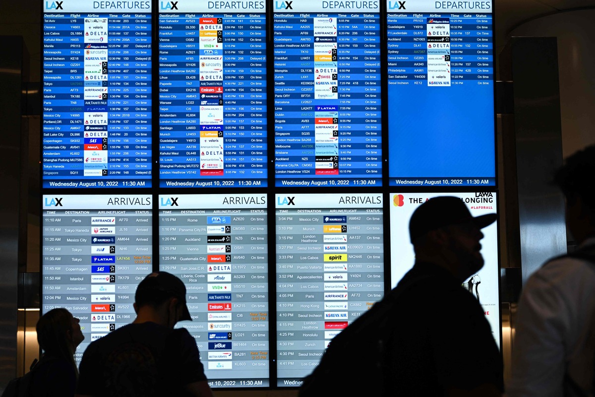 (FILES) In this file photo taken on August 10, 2022, passengers look at flight departure information boards in the West Gates expansion area at Los Angeles International Airport (LAX) in Los Angeles, California. The websites for a number of major US airports were briefly taken offline on October 10, 2022, after a cyberattack promoted by a pro-Russian hacking group. (Photo by Patrick T. FALLON / AFP)