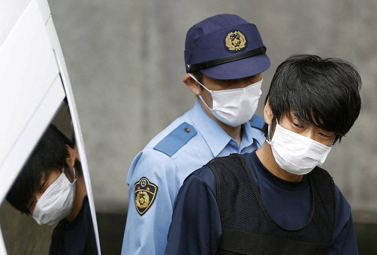 FILE PHOTO: Tetsuya Yamagami, suspected of killing former Japanese Prime Minister Shinzo Abe, is escorted by a police officer as he is taken to prosecutors, at Nara-nishi police station in Nara, western Japan, in this photo taken by Kyodo July 10, 2022. Mandatory credit Kyodo via REUTERS ATTENTION EDITORS - THIS IMAGE WAS PROVIDED BY A THIRD PARTY. MANDATORY CREDIT. JAPAN OUT. NO COMMERCIAL OR EDITORIAL SALES IN JAPAN./File Photo