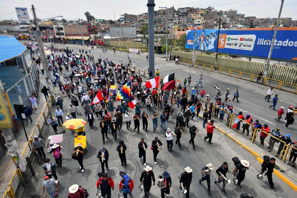 Demonstrators march to the city's main square during a protest to demand the resignation of President Dina Boluarte, at the main square in Arequipa, Peru, on January 19, 2023. After weeks of unrest, thousands of protesters were expected to descend on Peru's capital Lima, defying a state of emergency to express their anger with President Dina Boluarte, who called on the demonstrators to gather "peacefully and calmly". The South American country has been rocked by over five weeks of deadly protests since the ouster and arrest of her predecessor Pedro Castillo in early December. (Photo by Diego Ramos / AFP)