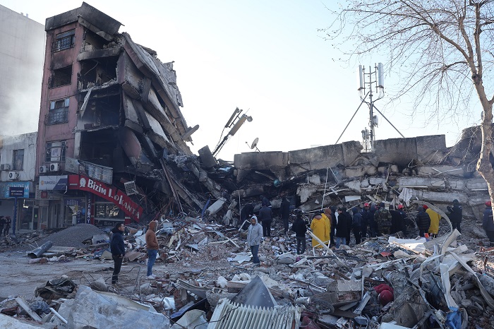 Rescuers and civilians look for survivors under the rubble of collapsed buildings in Kahramanmaras, southern Turkey, a day after a 7.8-magnitude earthquake struck the country's southeast, on February 7, 2023. - Rescuers in Turkey and Syria braved frigid weather, aftershocks and collapsing buildings, as they dug for survivors buried by an earthquake that killed more than 5,000 people. Some of the heaviest devastation occurred near the quake's epicentre between Kahramanmaras and Gaziantep, a city of two million where entire blocks now lie in ruins under gathering snow. (Photo by Adem ALTAN / AFP)