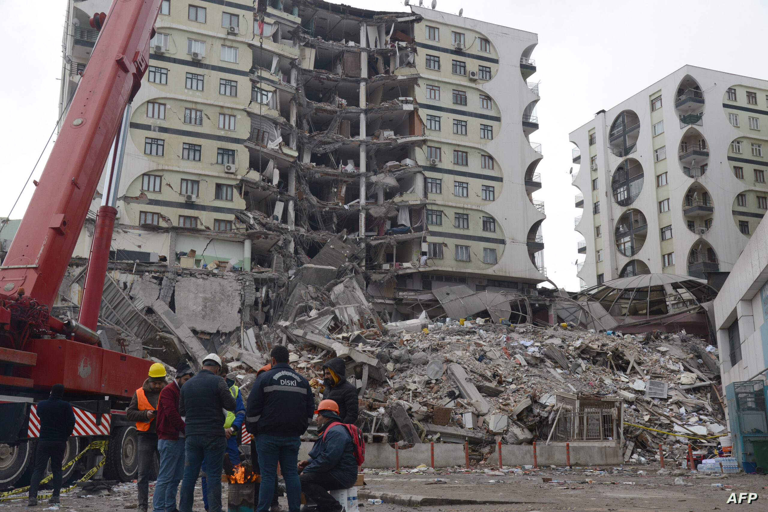 Rescue workers and volunteers conduct search and rescue operations in the rubble of a collasped building, in Diyarbakir on February 6, 2023, after a 7.8-magnitude earthquake struck the country's south-east. - The combined death toll has risen to over 1,900 for Turkey and Syria after the region's strongest quake in nearly a century. Turkey's emergency services said at least 1,121 people died in the earthquake, with another 783 confirmed fatalities in Syria. (Photo by ILYAS AKENGIN / AFP)