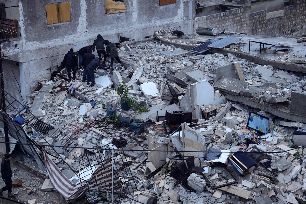 EDITORS NOTE: Graphic content / Residents search for victims and survicors amidst the rummble of a building that collapsed, following an earthquake in the village of Azmarin, near the Turkish border in the north of Syria's rebel-held northwestern Idlib province, early on February 6, 2023. At least 100 have been reportedly killed in north Syria after a 7.8-magnitude earthquake that originated in Turkey and was felt across neighbouring countries. (Photo by OMAR HAJ KADOUR / AFP)