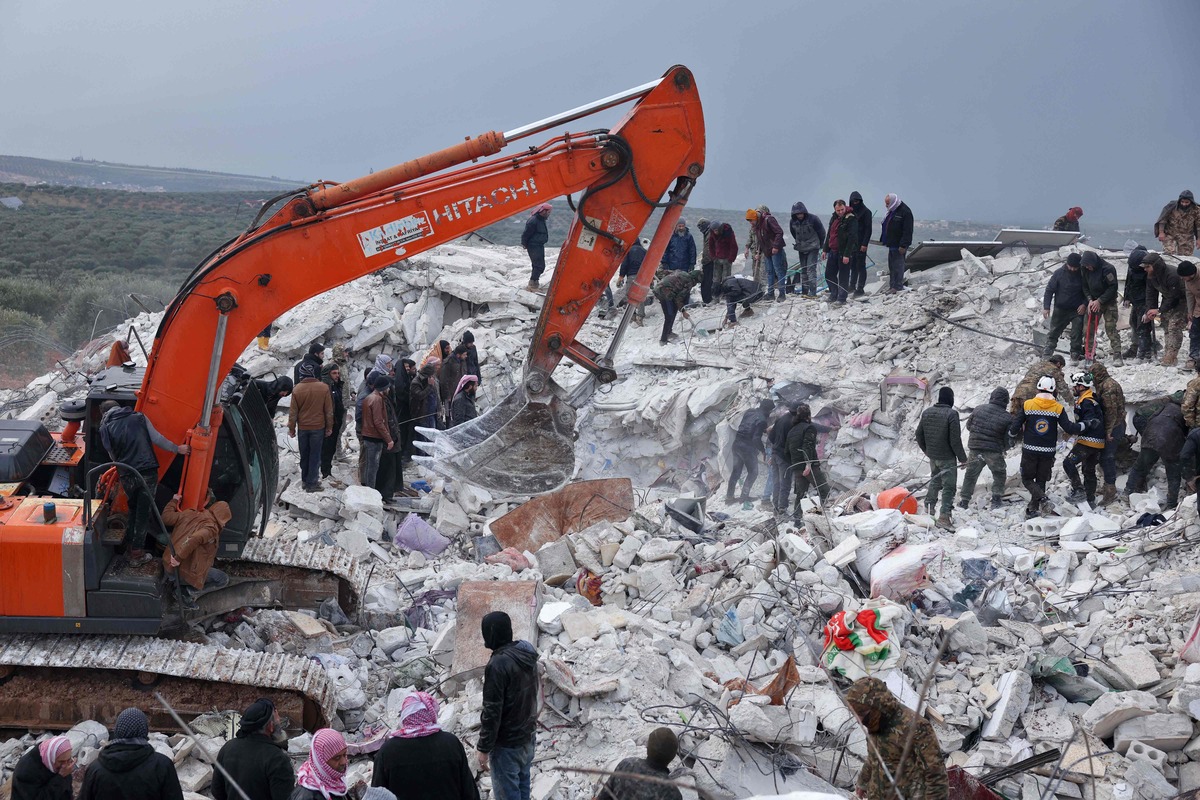 Residents and rescuers search for victims and survivors amidst the rubble of collapsed buildings following an earthquake in the village of Besnaya in Syria's rebel-held northwestern Idlib province on the border with Turkey, on February 6, 2022. At least 1,293 people were killed and 3,411 injured across Syria today in an earthquake that had its epicentre in southwestern Turkey, the government and rescuers said. (Photo by OMAR HAJ KADOUR / AFP)