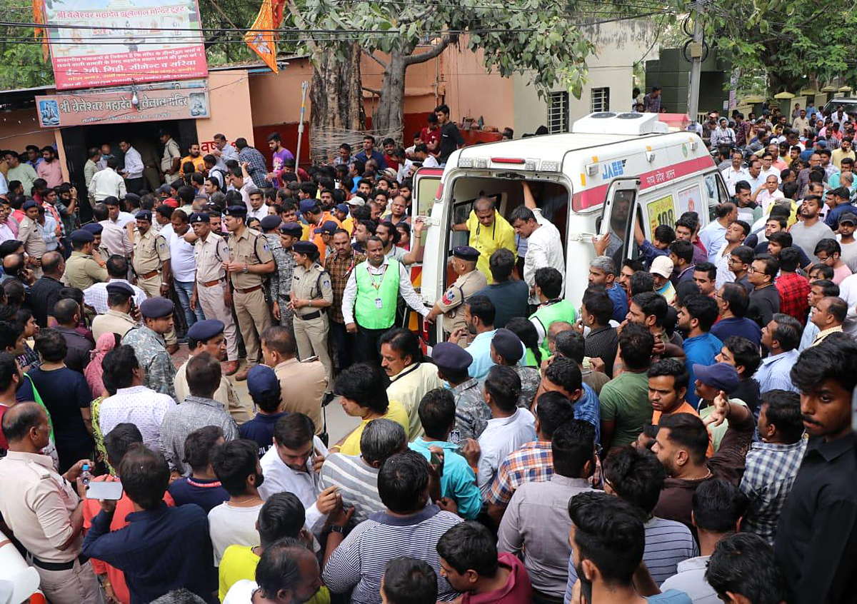 (230330) -- INDORE (INDIA), March 30, 2023 (Xinhua) -- People gather outside the site of a floor cave-in at a temple in Indore, Madhya Pradesh state, India, on March 30, 2023. At least 13 people died and several others were injured in a floor cave-in at a temple in India's central state of Madhya Pradesh on Thursday, the state's Home Minister Narottam Mishra said. (Str/Xinhua)