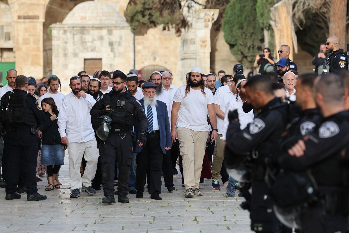 Jewish visitors walk protected by Israeli security forces at the Al-Aqsa mosque compound, also known as the Temple Mount complex to Jews, in Jerusalem on April 9, 2023, during the Muslim holy fasting month of Ramadan, also coinciding with the Jewish Passover holiday. (Photo by AHMAD GHARABLI / AFP)