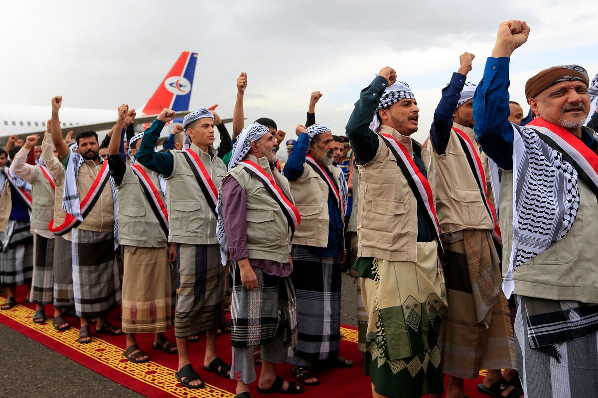 Yemeni Huthi rebel prisoners stand on a red carpet during a welcome ceremony upon their arrival at Sanaa airport on April 14, 2023. An exchange of nearly 900 prisoners between the two sides of the nine-year-old civil war started on April 14, the biggest swap since 2020, after a delegation from Saudi Arabia held talks with the Iran-backed Huthi rebels in an attempt to end hostilities. (Photo by Mohammed HUWAIS / AFP)