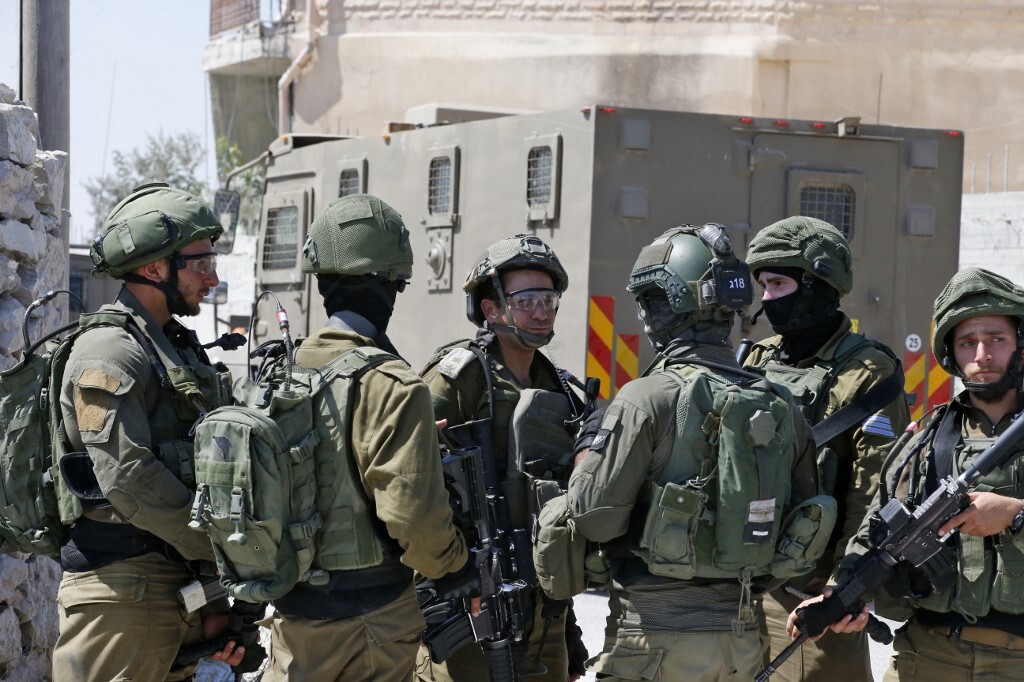 Israeli soldiers stand guard during a house-to-house search operation in the West Bank village of Beit Fajjar near Bethlehem on August 8, 2019, following a stabbing attack. - An off-duty Israeli soldier was found dead with stab wounds near a Jewish settlement in the occupied West Bank today in what Prime Minister Benjamin Netanyahu called a "terrorist" attack, sparking a manhunt. Details were still emerging of the killing, but it risked raising Israeli-Palestinian tensions weeks ahead of September 17 Israeli polls. (Photo by HAZEM BADER / AFP)