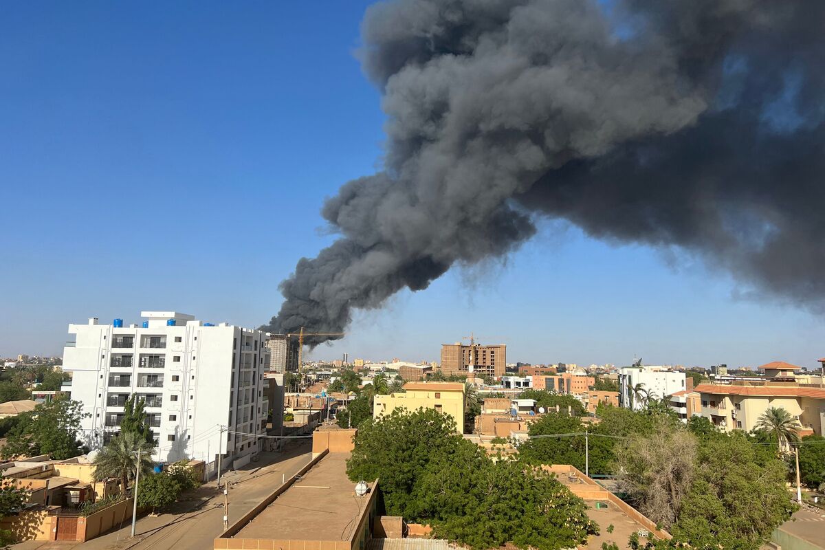 A column of smoke rises behind buildings near the airport area in Khartoum on April 19, 2023, amid fighting between the army and paramilitaries following the collapse of a 24-hour truce. (Photo by AFP)