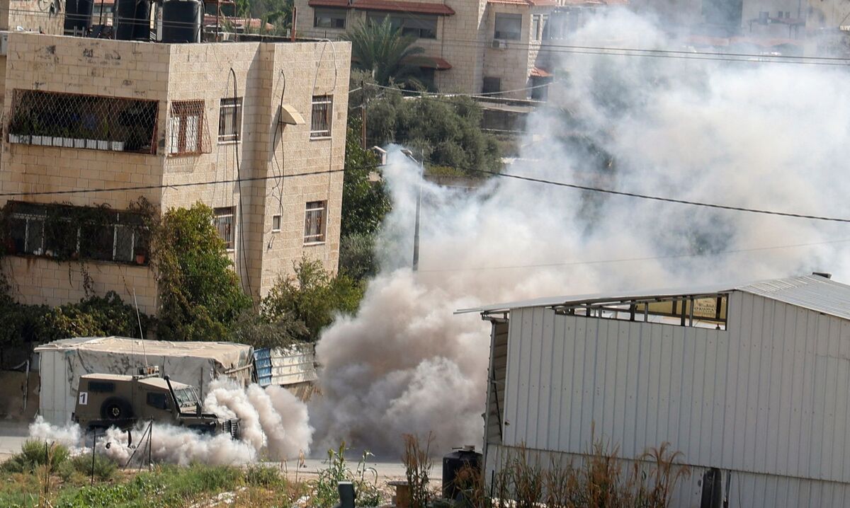 EDITORS NOTE: Graphic content / Smoke billows around Israeli security forces vehicles during a reported operation in Jenin city in the occupied West Bank, on Octobre 8, 2022. Two Palestinians were shot dead by Israeli forces and multiple others wounded in the occupied West Bank city of Jenin, the Palestinian health ministy said. The Israeli military said the security forces carried out an operation to detain a 25-year-old Palestinian, who the army said is a member of the Islamic Jihad militant group and suspected of shooting at troops in the area. (Photo by JAAFAR ASHTIYEH / AFP)