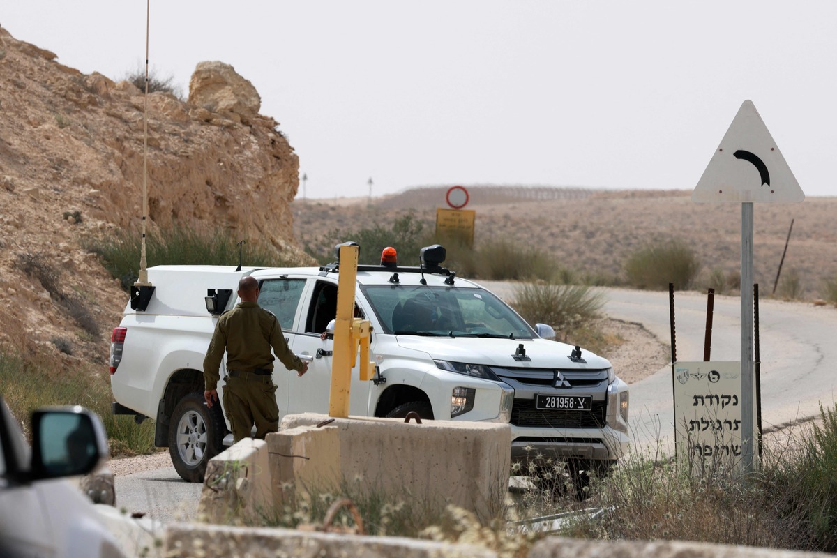 An Israeli soldier walks up to a military vehicle close to the Mount Harif military base near the city of Mitzpe Ramon in Israel's southern Negev desert, adjacent to the border with Egypt, on June 3, 2023. Two Israeli soldiers were killed in a rare shooting on the Egyptian border, triggering a manhunt in which a third soldier and the "assailant" were killed, the army said. (Photo by Menahem KAHANA / AFP)