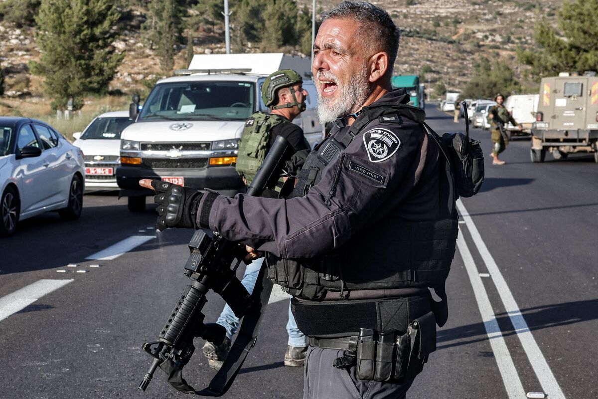 An Israeli policeman speaks at the scene of an attack near the Jewish settlement of Eli in the north of the occupied West Bank on June 20, 2023. Four people were shot dead on June 20 near the settlement in the occupied West Bank, Israeli officials said, a day after an army raid left six Palestinians dead. (Photo by AHMAD GHARABLI / AFP)