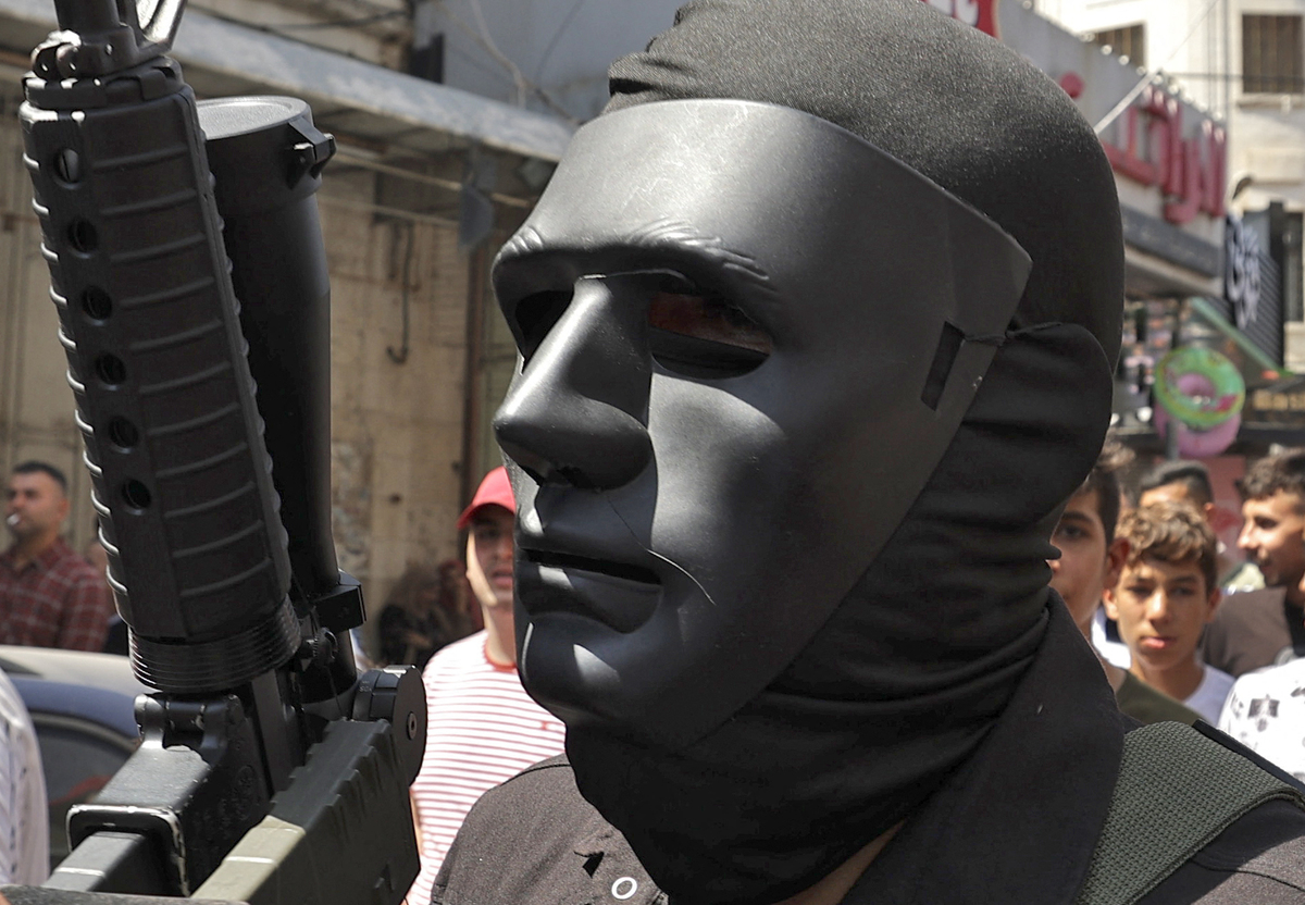 Militants march during the funeral of slain Palestinian Mohamed Arayshi, 25, in the city of Nablus in the north of the occupied West Bank on August 23, 2022. Arayshi died on August 23 from wounds sustained weeks earlier on August 9 during clashes with Israeli forces in the old city of Nablus. The Israeli military had then said that it had carried out an operation to "secure the entrance of (Jewish) worshippers to Joseph's Tomb in the city of Nablus". The tomb, which is believed by some to be the last resting place of the biblical patriarch Joseph, is a flashpoint for violence in the West Bank, and revered as a holy site by some Muslims. (Photo by JAAFAR ASHTIYEH / AFP)