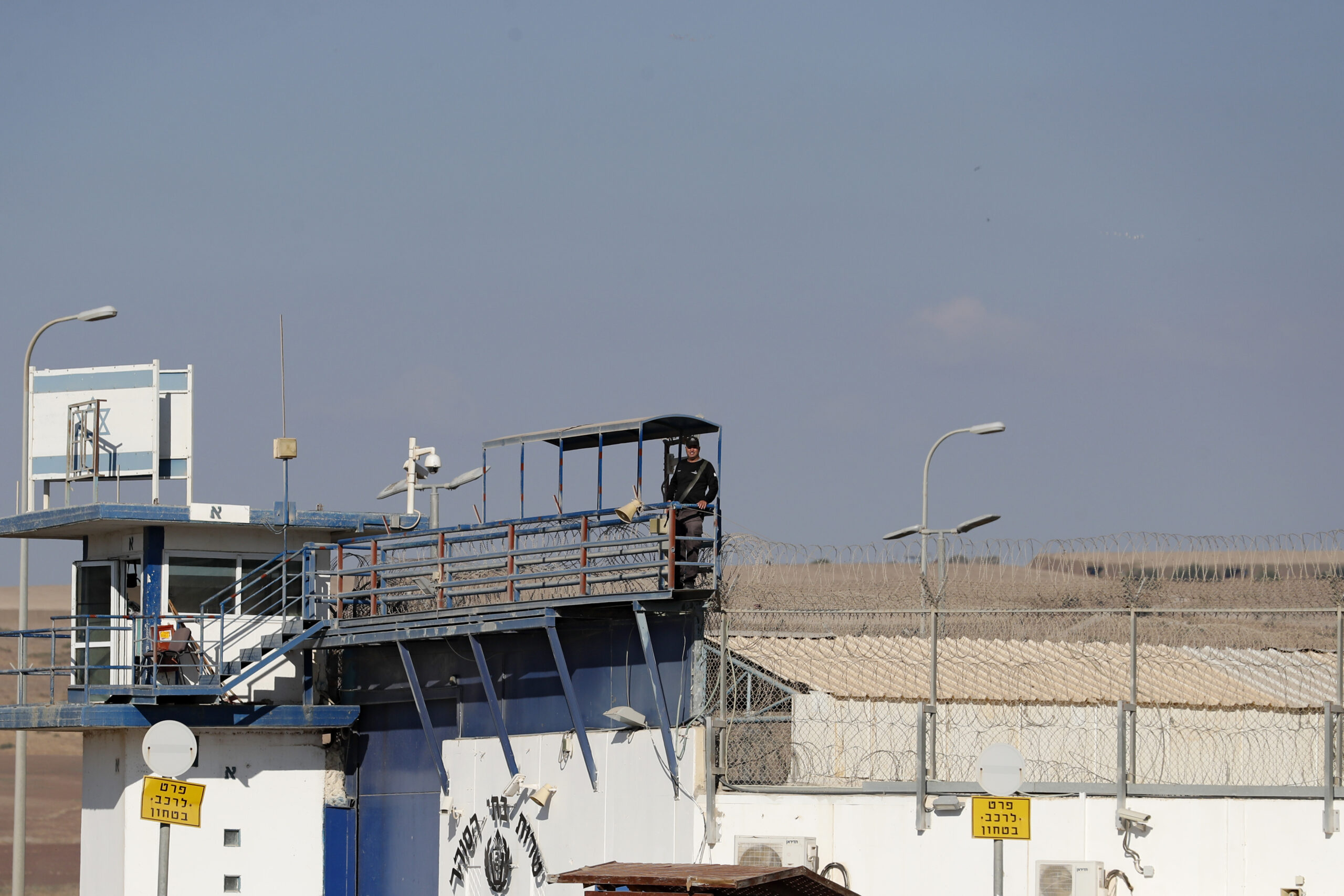 A member of the Israeli security forces stands guard at the Gilboa prison in northern Israel on September 18, 2021, as Arab-Israelis gather outside the prison to express their support of the Palestinian prisoners in Israeli jails. - Six inmates staged a dramatic escape from Gilboa jail in northern Israel on September 6 after digging a tunnel under a sink in their cell and making their way to freedom. (Photo by Ahmad GHARABLI / AFP)