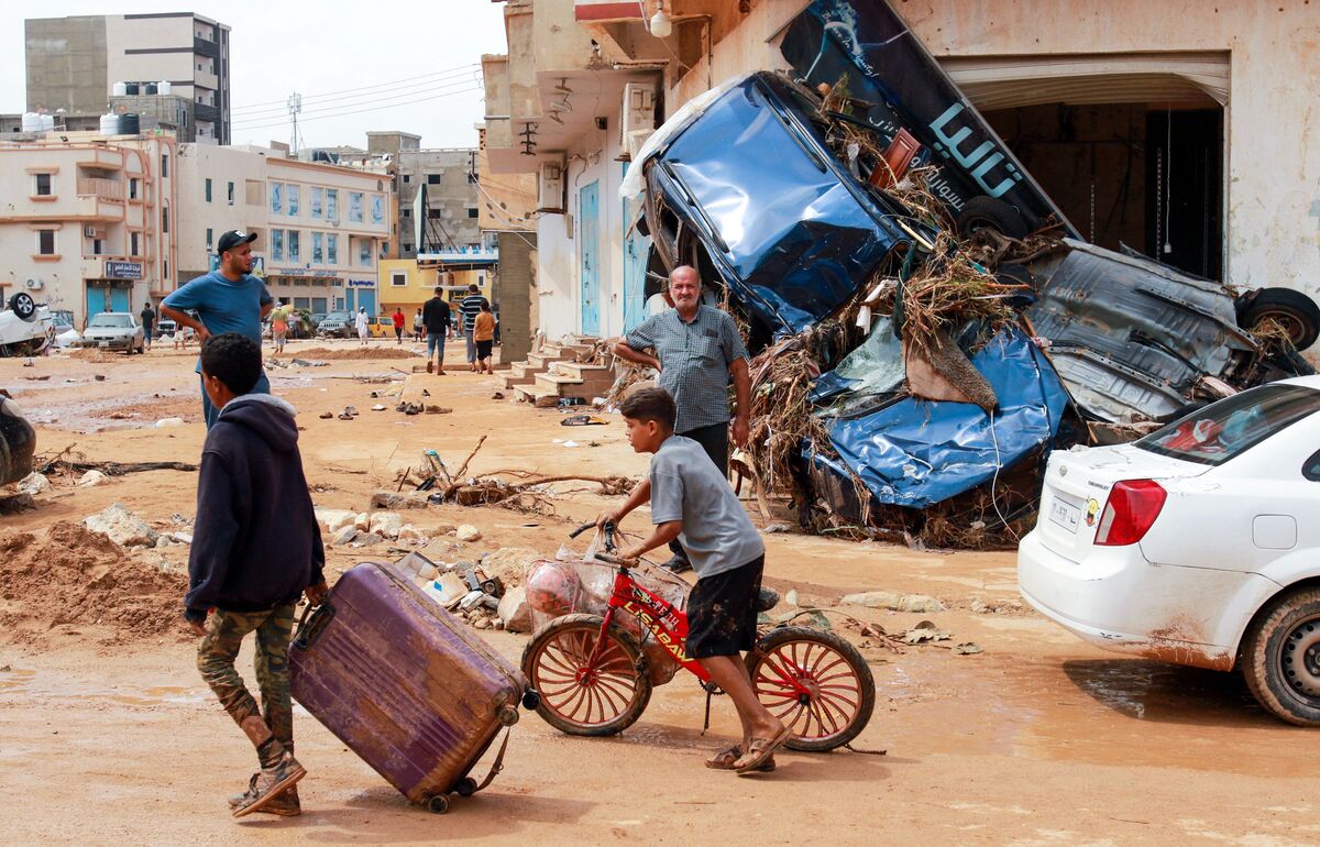 TOPSHOT - A boy pulls a suitcase past debris in a flash-flood damaged area in Derna, eastern Libya, on September 11, 2023. Flash floods in eastern Libya killed more than 2,300 people in the Mediterranean coastal city of Derna alone, the emergency services of the Tripoli-based government said on September 12. (Photo by AFP)