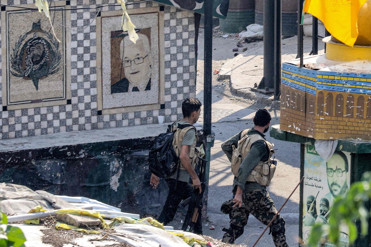 Fighters of the Palestinian Fatah movement walk during clashes at one of its centres in the Ain al-Helweh camp for Palestinian refugees in Lebanon's southern coastal city of Sidon on September 10, 2023, amid renewed clashes between Fatah fighters and Islamists. (Photo by Mahmoud ZAYYAT / AFP)