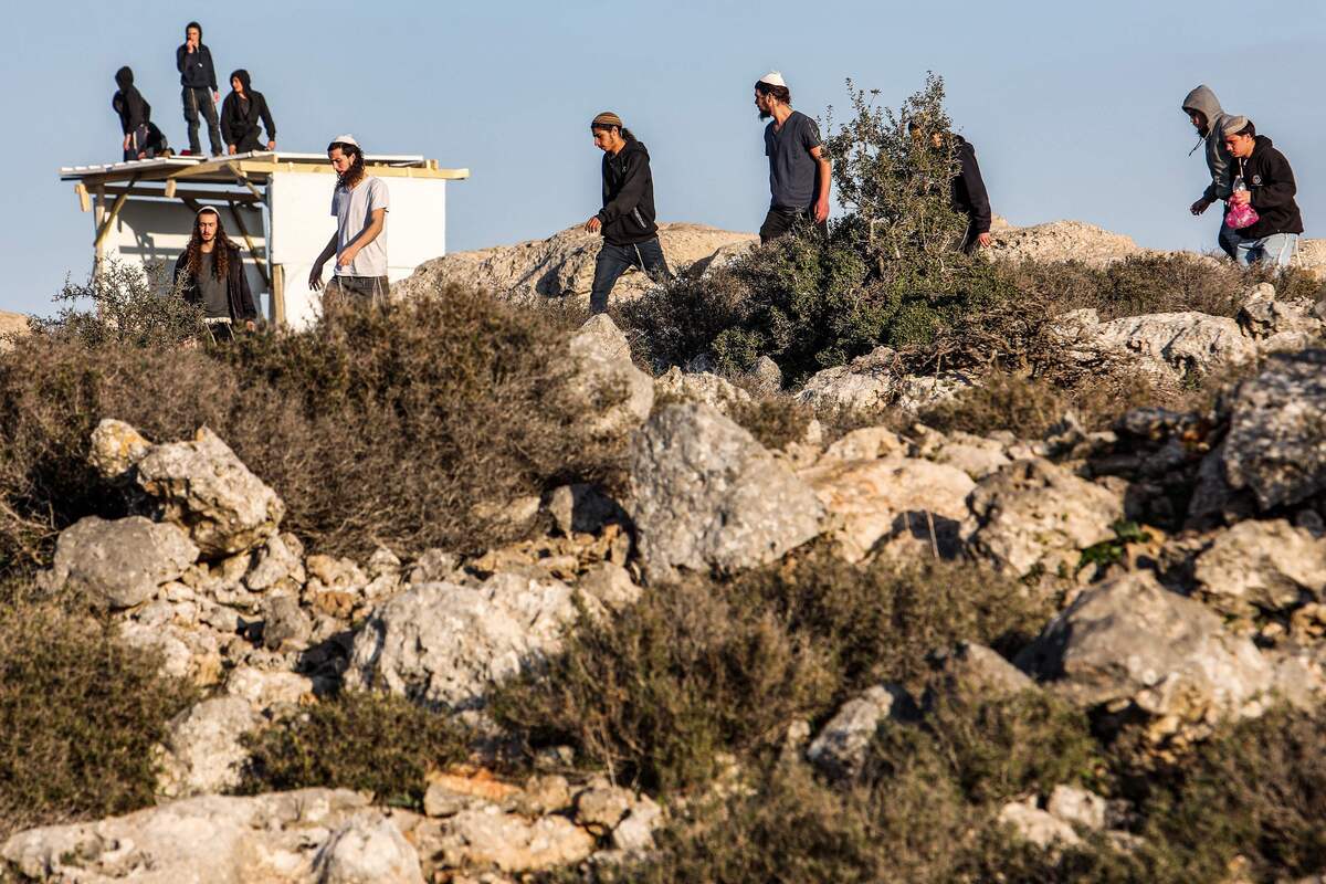 Israeli settlers gather in an attempt to reestablish an illegal settlement outpost called Or Haim, near the settelment of Migdalim, in the north of occupied West Bank on January 22, 2023. (Photo by GIL COHEN-MAGEN / AFP)