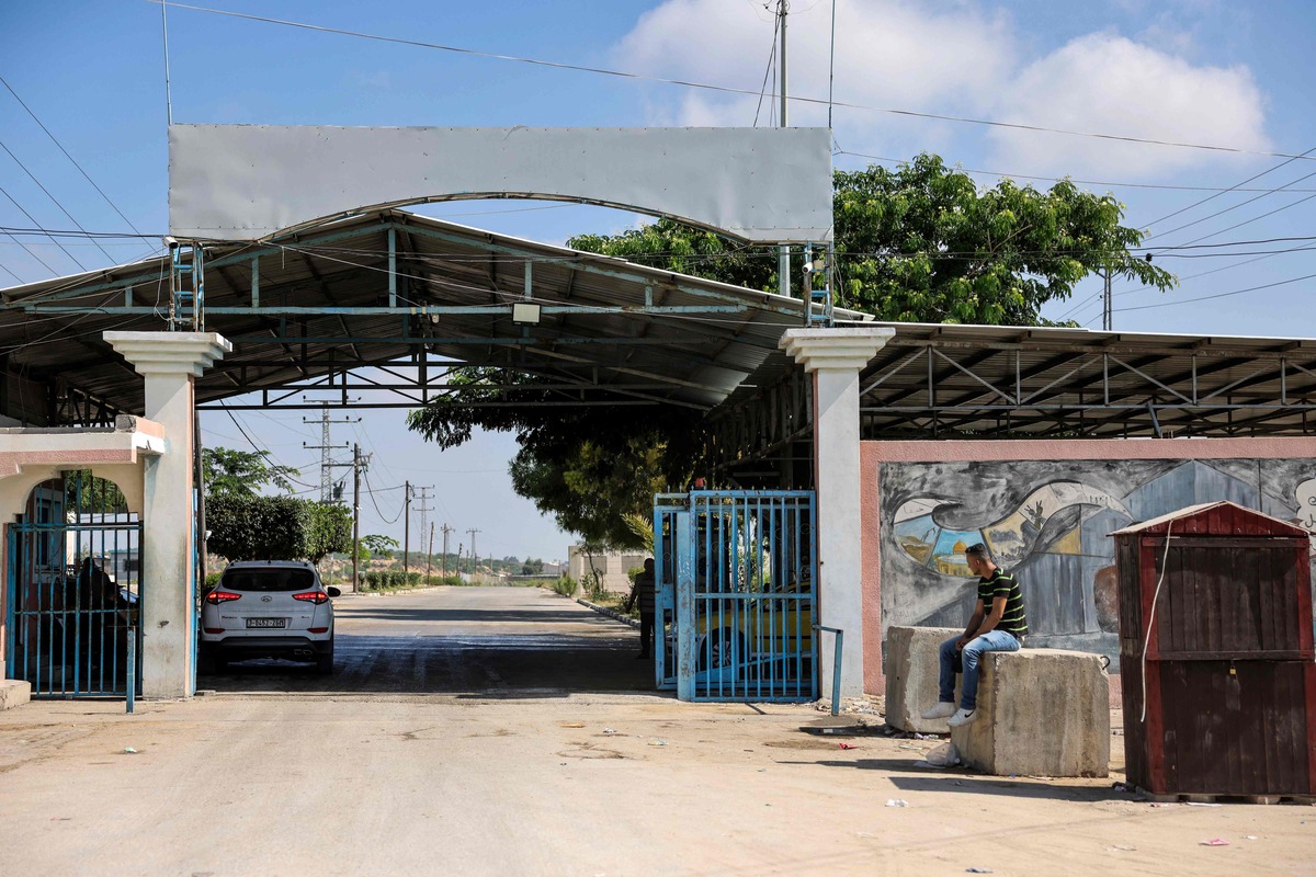 A Palestinian man sits on a concrete cube outside the gate on the Palestinian side of the Erez border crossing between the Gaza Strip and Israel on September 18, 2023. A new deal for visa-free travel between Israel and the United States has raised hopes of easier journeys for Palestinian-Americans, but discrimination by Israeli authorities persists, according to some travellers. (Photo by MOHAMMED ABED / AFP)