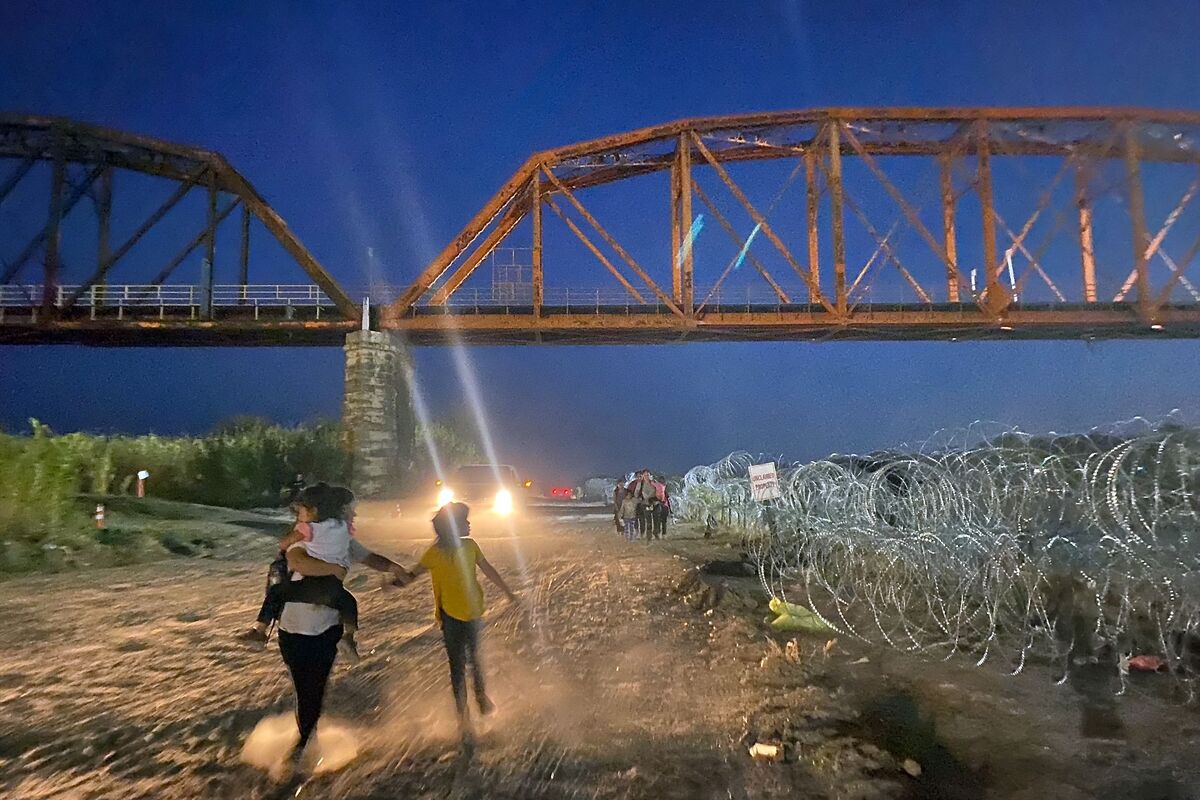 Migrants walk after wading the Rio Grande in the US-Mexico border in Eagle Pass, Texas on September 22, 2023. (Photo by Paula RAMON / AFP)