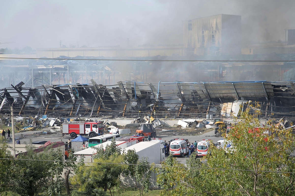 Rescuers work as smoke stills rising on September 28, 2023 at the site of an explosion at a warehouse near the airport in Tashkent that caused multiple injuries, authorities in the Central Asian country said. The health ministry said the fire broke out in a warehouse in the airport zone. The country's biggest airport is functioning normally, according to the Uzbek national news agency UZa. The blast blew out the windows of several houses in the surrounding area and damaged their interiors, while ambulances worked to evacuate those injured, an AFP journalist on the scene witnessed. (Photo by Temur ISMAILOV / AFP)