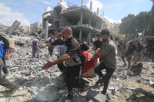 (231017) -- GAZA, Oct. 17, 2023 (Xinhua) -- People remove a victim from a building destroyed in Israeli airstrikes in the southern Gaza Strip city of Rafah, on Oct. 17, 2023. The number of Palestinian deaths caused by Israeli airstrikes in Gaza has risen to 3,000, according to the Gaza-based Health Ministry. The Israeli airstrikes were triggered by a large-scale Hamas attack on Israeli military targets and towns on Oct. 7, which has so far killed at least 1,300 people in Israel. (Photo by Khaled Omar/Xinhua)