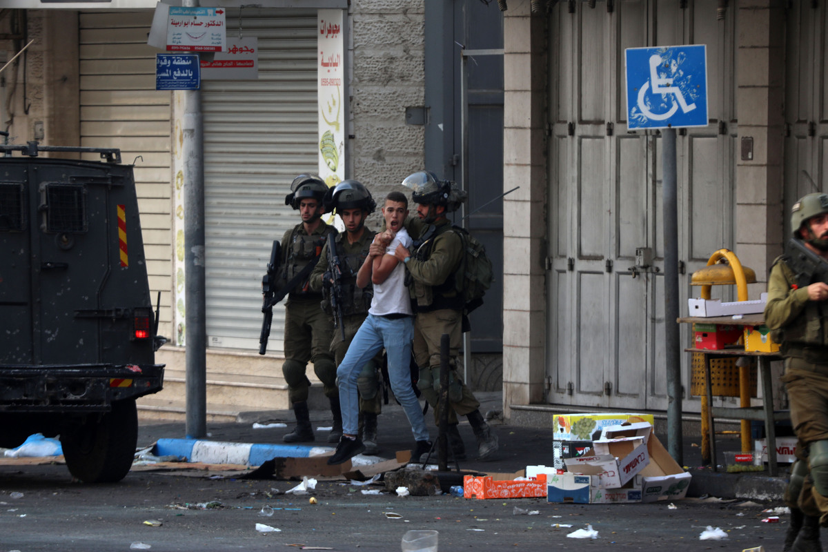 (221012) -- HEBRON, Oct. 12, 2022 (Xinhua) -- Israeli security forces detain a Palestinian protester during clashes in the West Bank city of Hebron, on Oct. 12, 2022. (Photo by Mamoun Wazwaz/Xinhua)