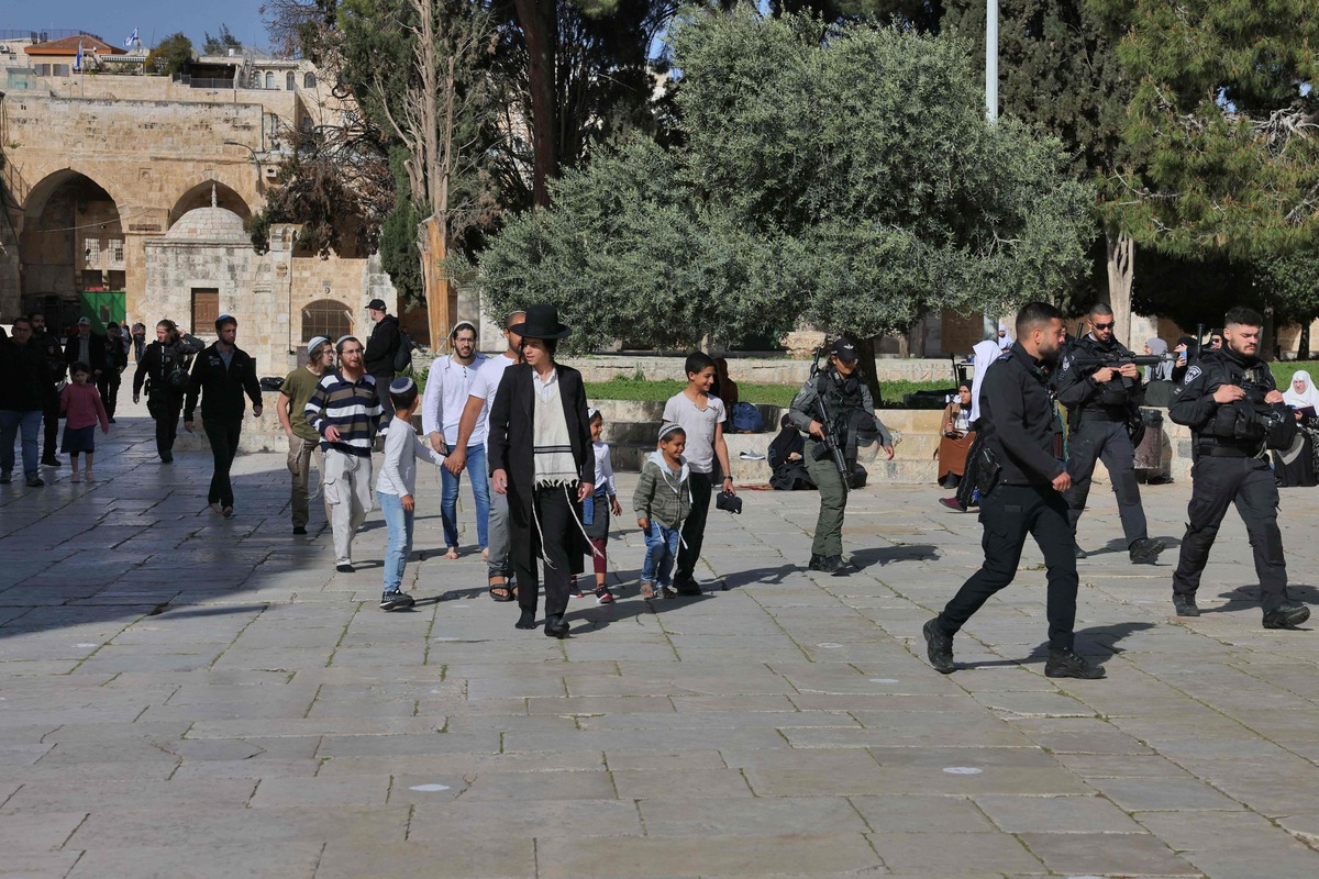 Jewish worshippers walk protected by Israeli security forces at the Al-Aqsa mosque compound in Jerusalem, early on April 5, 2023 during Islam's holy month of Ramadan. Israeli police said they had entered to dislodge "agitators", a move denounced as an "unprecedented crime" by the Palestinian Islamist movement Hamas. The holy Muslim site is built on top of what Jews call the Temple Mount, Judaism's holiest site. (Photo by AHMAD GHARABLI / AFP)