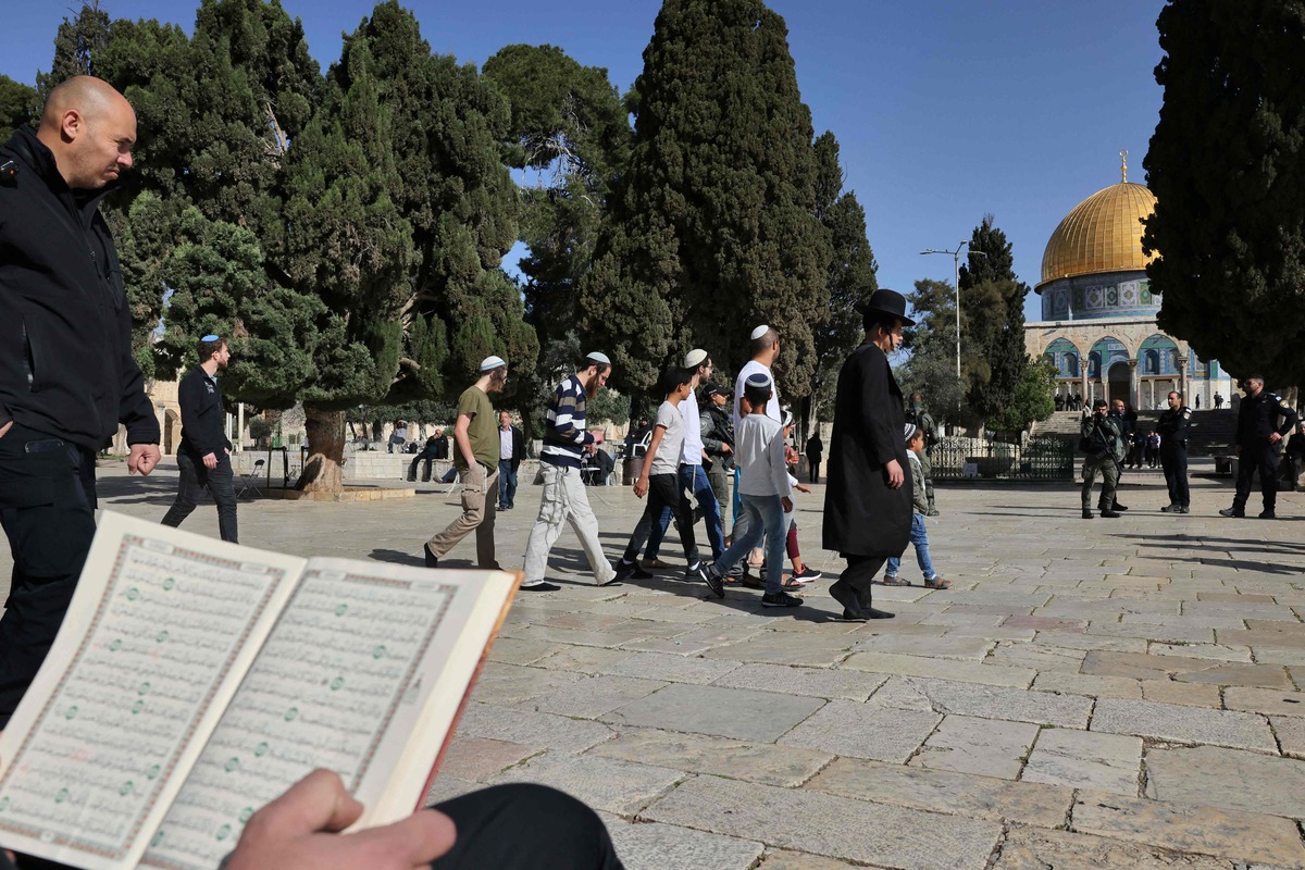 Jewish worshippers walk protected by Israeli security forces at the Al-Aqsa mosque compound in Jerusalem, early on April 5, 2023 during Islam's holy month of Ramadan. Israeli police said they had entered to dislodge "agitators", a move denounced as an "unprecedented crime" by the Palestinian Islamist movement Hamas. The holy Muslim site is built on top of what Jews call the Temple Mount, Judaism's holiest site. (Photo by AHMAD GHARABLI / AFP)