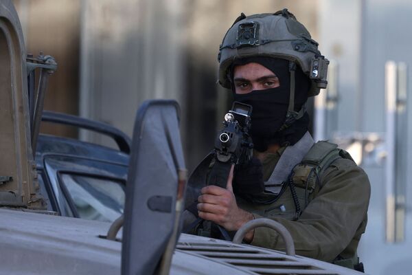 An Israeli soldier stands guard during an operation near the Jit junction west of Nablus in the occupied northern West Bank on March 12, 2023. Israeli forces shot dead three Palestinian gunmen after they fired at troops near Nablus, the army announced early in the morning. Palestinian medical and security sources had no information on the event. (Photo by jaafar ashtiyeh / AFP)