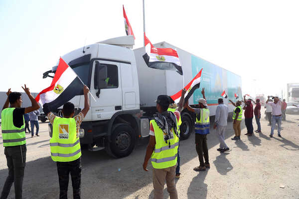 (231022) -- RAFAH, Oct. 22, 2023 (Xinhua) -- Trucks loaded with humanitarian aid prepare to enter Gaza at the Egyptian side of the Rafah border crossing on Oct. 22, 2023. A convoy of 17 trucks carrying humanitarian aid reached the Egyptian side of the Rafah border crossing on Sunday, before heading to the besieged Gaza Strip which is experiencing a humanitarian crisis due to Israeli airstrikes, Egyptian humanitarians at the border said. It is the second aid convoy to be sent to Gaza after the first convoy of 20 trucks carrying humanitarian supplies entered the coastal enclave on Saturday. (Xinhua/Ahmed Gomaa)