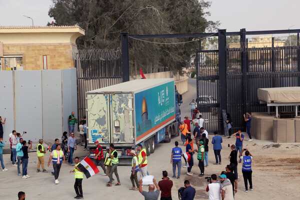 (231022) -- RAFAH, Oct. 22, 2023 (Xinhua) -- A truck loaded with humanitarian aid enters Gaza from the Egyptian side of the Rafah border crossing on Oct. 22, 2023. A convoy of 17 trucks carrying humanitarian aid reached the Egyptian side of the Rafah border crossing on Sunday, before heading to the besieged Gaza Strip which is experiencing a humanitarian crisis due to Israeli airstrikes, Egyptian humanitarians at the border said. It is the second aid convoy to be sent to Gaza after the first convoy of 20 trucks carrying humanitarian supplies entered the coastal enclave on Saturday. (Xinhua/Ahmed Gomaa)