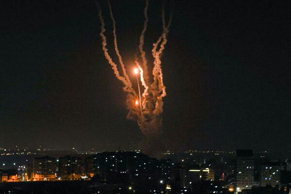 Israel's Iron Dome air defence system intercepts rockets launched from Gaza City, on May 10, 2023. Israel's army and Gaza militants traded heavy cross-border fire on May 10, with 22 Palestinians killed over two days amid the worst escalation of violence to hit the coastal territory in months. (Photo by MAHMUD HAMS / AFP)