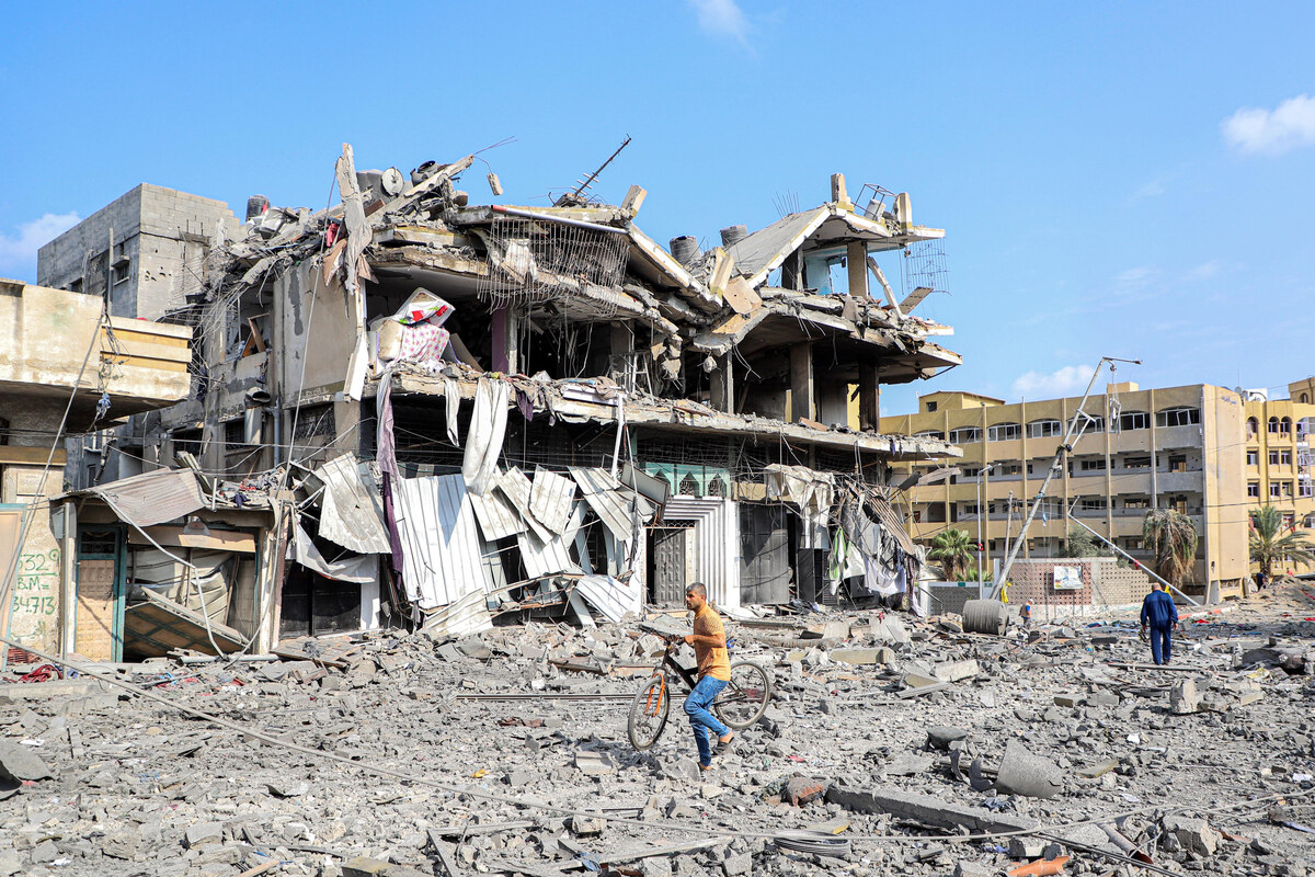 (231010) -- GAZA, Oct. 10, 2023 (Xinhua) -- People walk past destroyed buildings following an Israeli airstrike in Gaza City, on Oct. 10, 2023. (Photo by Rizek Abdeljawad/Xinhua)