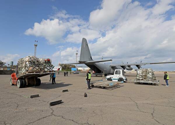 Workers load a military plane with humanitarian aid for Turkey and Syria, at Libya's Mitiga International Airport, east of the capital Tripoli, on February 12, 2023 following a devastating 7.8-magnitude earthquake. (Photo by Mahmud Turkia / AFP)