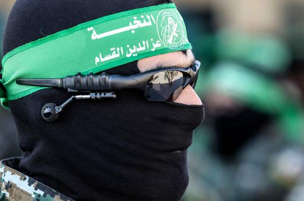 Masked members of the al-Qassam Brigades, the military wing of Hamas, march during a rally in Gaza City on July 20, 2022. (Photo by MAHMUD HAMS / AFP)