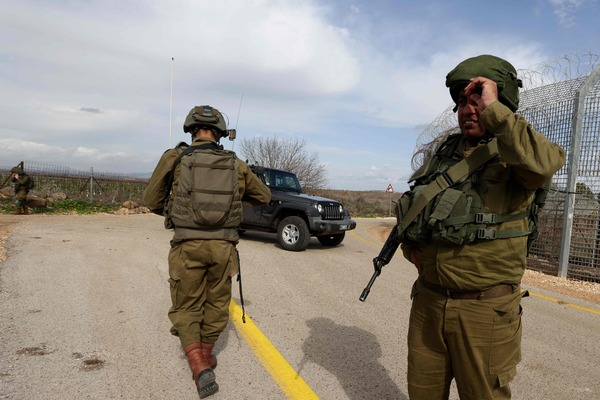 Israeli soldiers patrol next to section of the border fence between the Israeli-annexed Golan Heights and Syria on January 29, 2023, after Israeli soldiers opened fire towards two armed individuals, who were spotted crossing the border from Syria into Israeli territories. The Israeli army said that its soldiers opened fire towards two armed individuals, who were spotted crossing the border from Syria into Israeli territories and approached the security fence area in the southern Golan Heights. One of the armed individual was injured and received initial medical treatment from the soldiers at the scene. (Photo by JALAA MAREY / AFP)