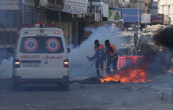 (230222) -- NABLUS, Feb. 22, 2023 (Xinhua) -- Palestinian rescuers carry an injured man to an ambulance during clashes with Israeli forces in the West Bank city of Nablus, Feb. 22, 2023. Palestinians on Wednesday condemned the killing of 10 Palestinians and wounding of 102 others during an Israeli raid in the northern West Bank city of Nablus. (Photo by Nidal Eshtayeh/Xinhua)