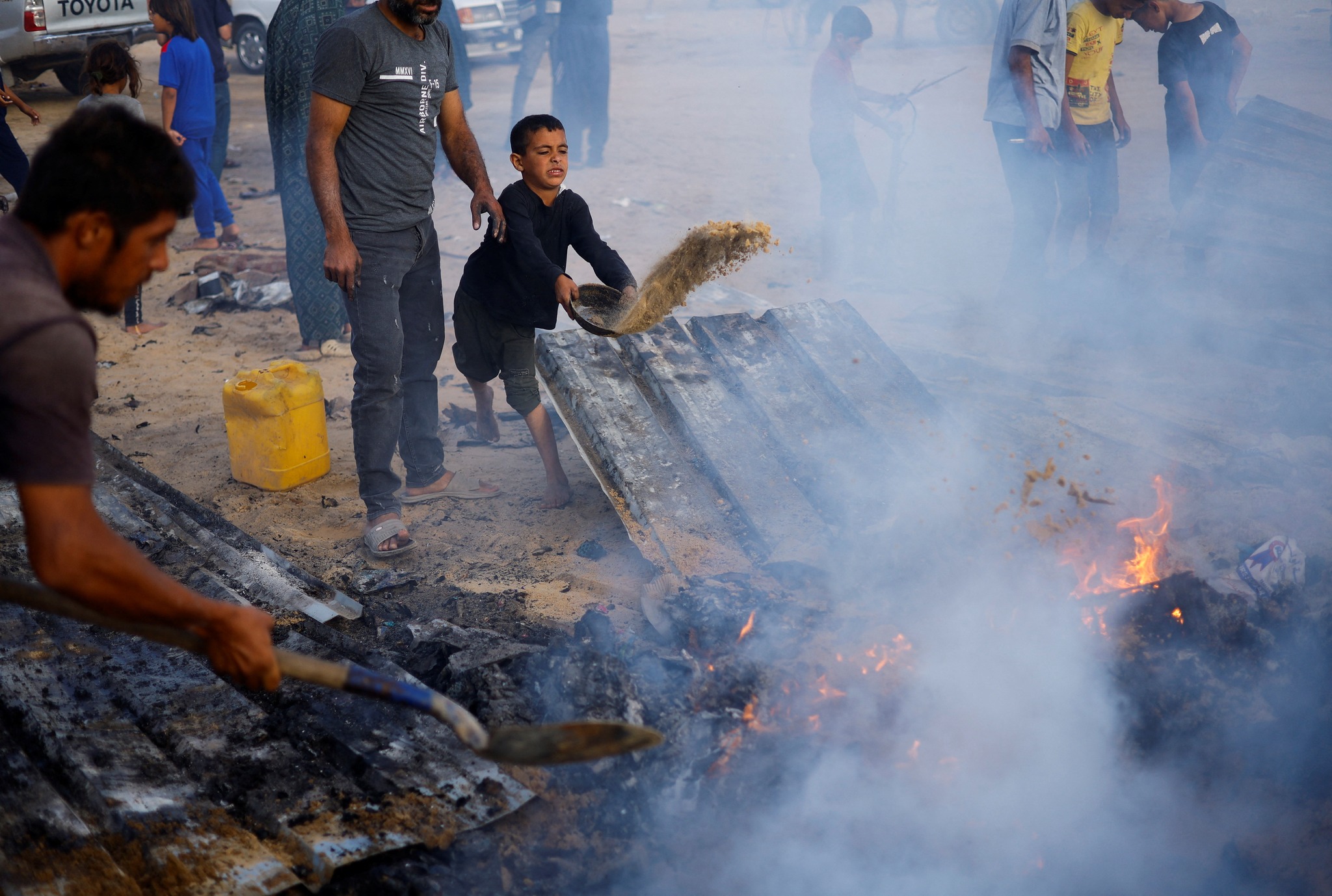 Palestinians put out a fire at the site of an Israeli strike on an area designated for displaced people, in Rafah, in the southern Gaza Strip, May 27, 2024. REUTERS/Mohammed Salem