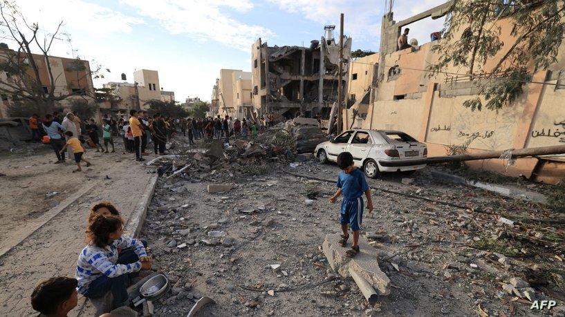 Palestinian children sit on the ground as people search through the rubble of a building after an Israeli strike in Khan Yunis in the southern Gaza Strip on October 17, 2023, amid the ongoing battles between Israel and the Palestinian group Hamas. The death toll from Israeli strikes on the Gaza Strip has risen to around 2,750 since Hamas's deadly attack on southern Israel last week, the Gaza health ministry said October 16. (Photo by MAHMUD HAMS / AFP)