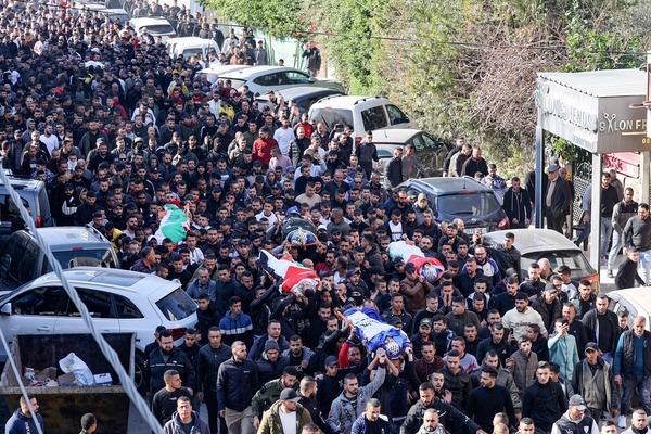 Palestinians carry the bodies of four of the 9 reported victims killed during an Israeli raid on the West Bank's Jenin refugee camp, during their funeral procession in the city of the same name, on January 26, 2023. An Israeli raid on Jenin refugee camp today killed 9 Palestinians including an elderly woman, Palestinian officials said, also accusing the army of using tear gas inside a hospital.Israel's army declined to comment when asked by AFP about the health minister's tear gas allegation. (Photo by JAAFAR ASHTIYEH / AFP)