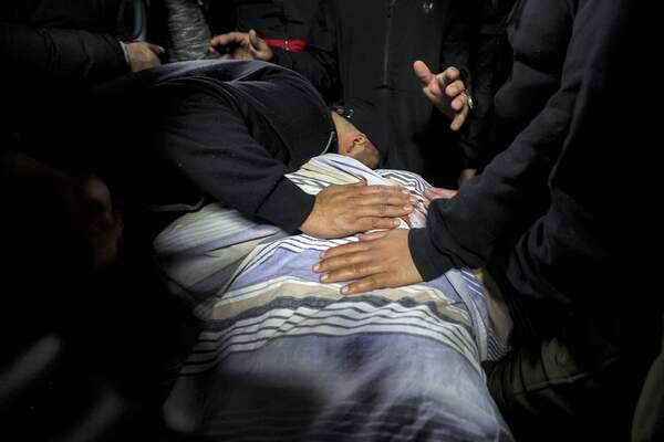 A mourner reacts by the body of Abdel Fatah Hussein Khroushah, a 49-year-old Palestinian designated by Israeli army for being a "terrorist operative" of the Islamist movement Hamas and accused of killing two Israeli settlers in the Palestinian town of Huwara on February 26, at a hospital in Nablus in the occupied West Bank on March 7, 2023 where it was taken after he was killed on the same day. (Photo by Zain Jaafar / AFP)