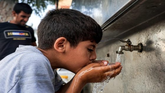 A Palestinian child drinks water with his hands from a cooler at a Bedouin village near Beit Lahia in the northern Gaza Strip onon August 28, 2023. Three decades after the Oslo Accords sprung hopes of Israeli-Palestinian peace, the outdated agreements are roundly seen as a failure which still control even every drop of water. (Photo by MAHMUD HAMS / AFP)